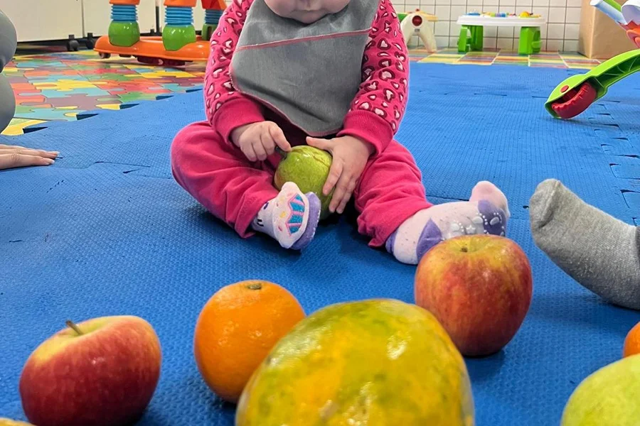 Criança participa de atividade de educação alimentar com frutas no projeto de extensão da Unesc no Bairro da Juventude, em Criciúma.