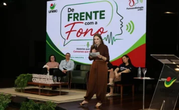 Unesc realiza aula inaugural de Fonoaudiologia em Criciúma Aula inaugural do curso de Fonoaudiologia da Unesc em Criciúma, com participante falando no palco durante o evento “De Frente com a Fono”.