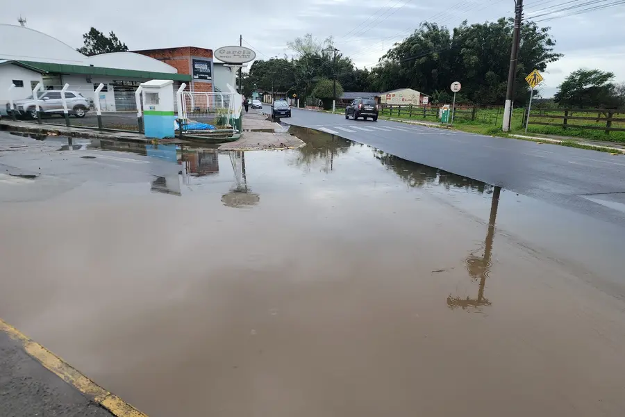 Alagamento na esquina das ruas Luiz Irineu Colares e Manoel Teixeira da Rosa, em Sombrio, dificulta a travessia de pedestres durante a chuva.