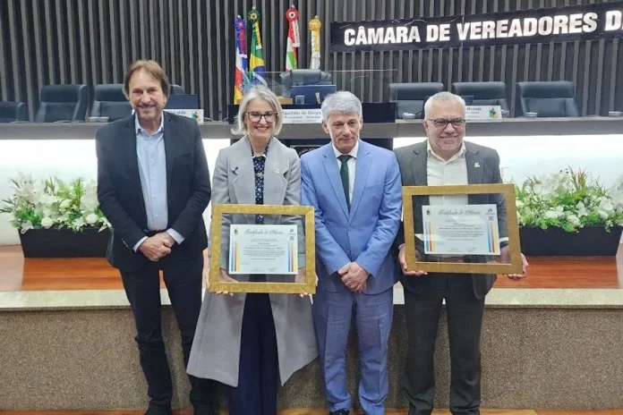 Unesc recebe homenagem por 58 anos e atuação em Araranguá : Representantes da Unesc e autoridades exibem certificados durante solenidade de reconhecimento à Universidade na Câmara de Vereadores de Araranguá.