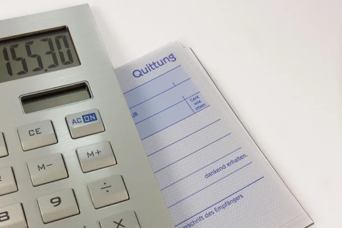 Dívida soma 42,24% do orçamento pago em 2025, aponta ACD Calculadora sobre bloco de recibos, em imagem ilustrativa de contas e despesas.