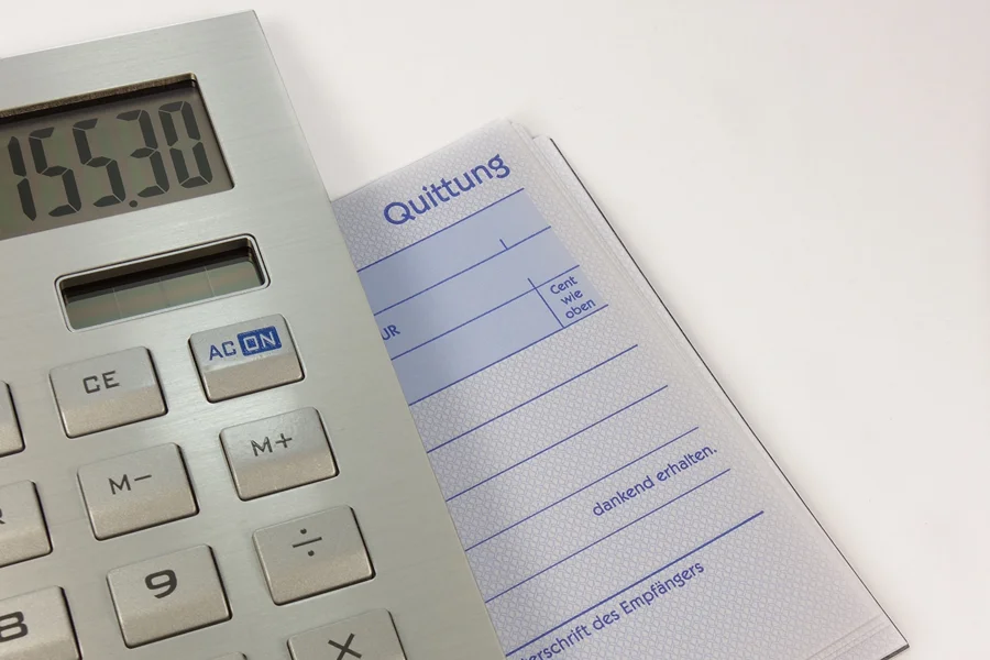 Calculadora sobre bloco de recibos, em imagem ilustrativa de contas e despesas.