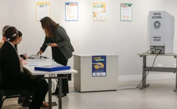 Eleitor deve deixar celular antes de entrar na cabine Eleitora entrega celular antes de acessar a cabine de votação durante as eleições de 2026.