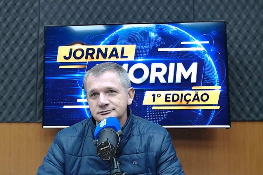 Carlos Alano, da Agro Alano Alimentos, fala ao microfone no estúdio do Jornal Amorim 1ª Edição sobre a produção de arroz em Sombrio.