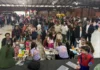 Crianças recebem pintura facial durante comemoração do Dia das Crianças no Pavilhão do Arroz, em Meleiro, acompanhadas por familiares.