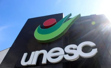 Unesc estreia no Prêmio IEL e fica entre cinco melhores Fachada da Unesc com o nome e o símbolo da Universidade sob céu azul.