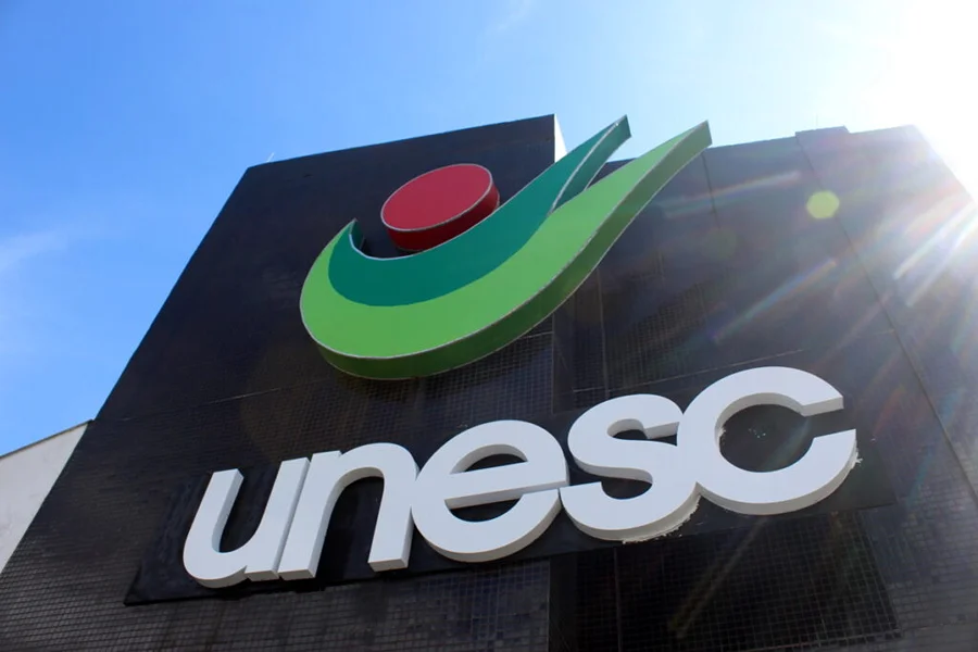 Unesc estreia no Prêmio IEL e fica entre cinco melhores Fachada da Unesc com o nome e o símbolo da Universidade sob céu azul.